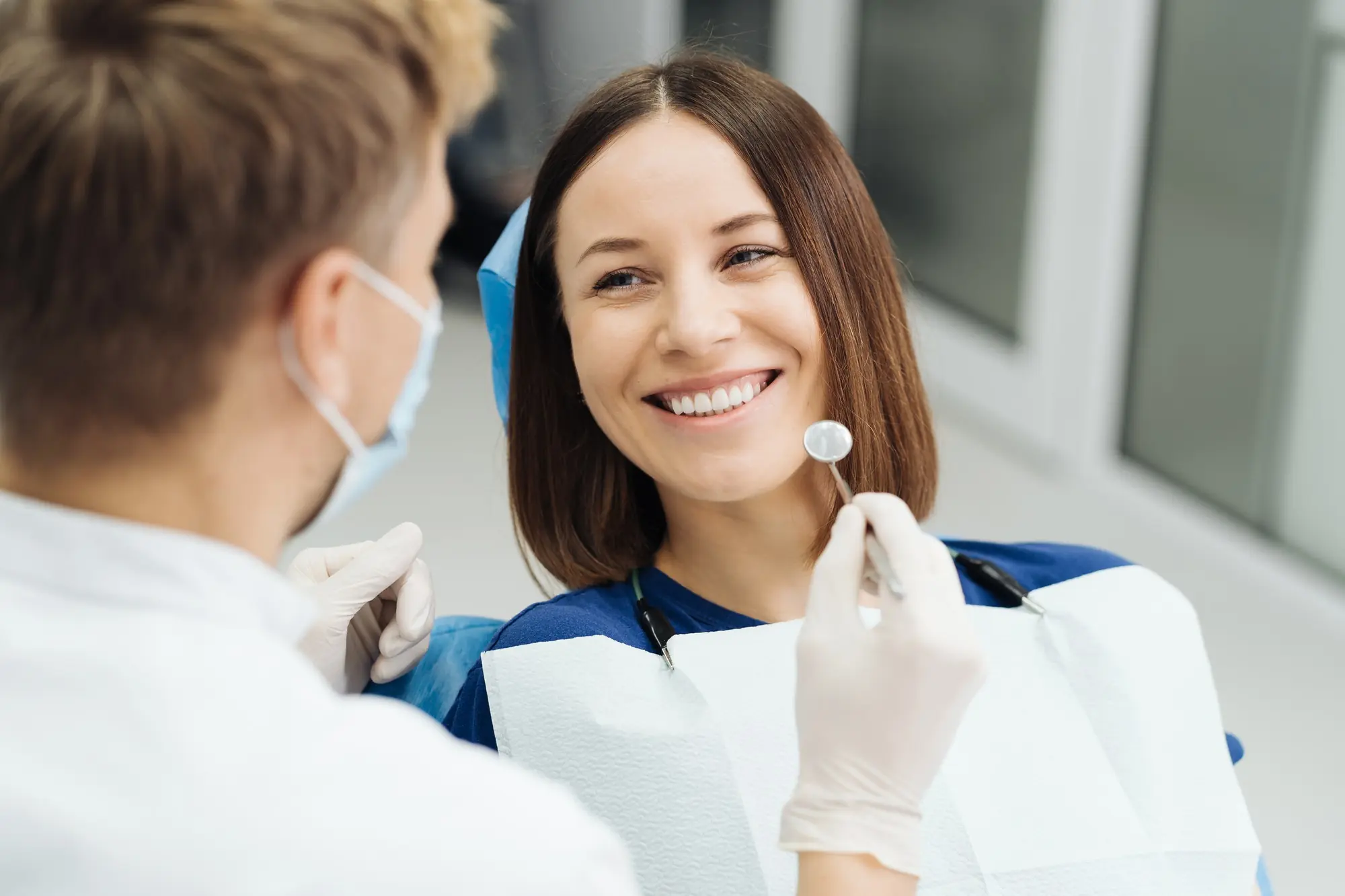 professional dentist with gloves and mask and discuss what the treatment should be
